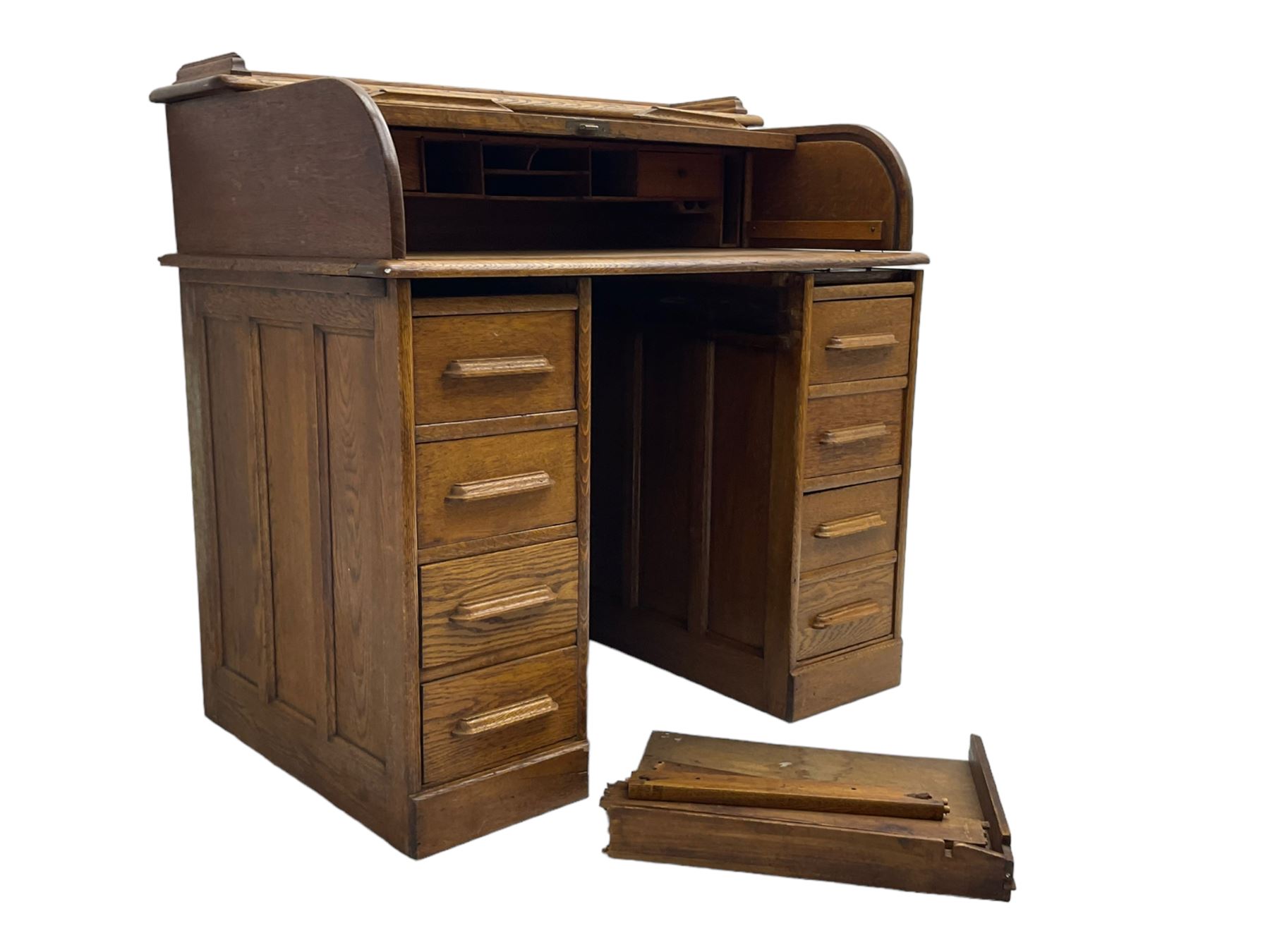 Early 20th century oak twin pedestal desk, tambour roll top enclosing fitted interior, eight drawers, on plinth base