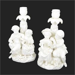 Pair of 19th century Meissen style Blanc de Chine figural candlesticks, each depicting chi...