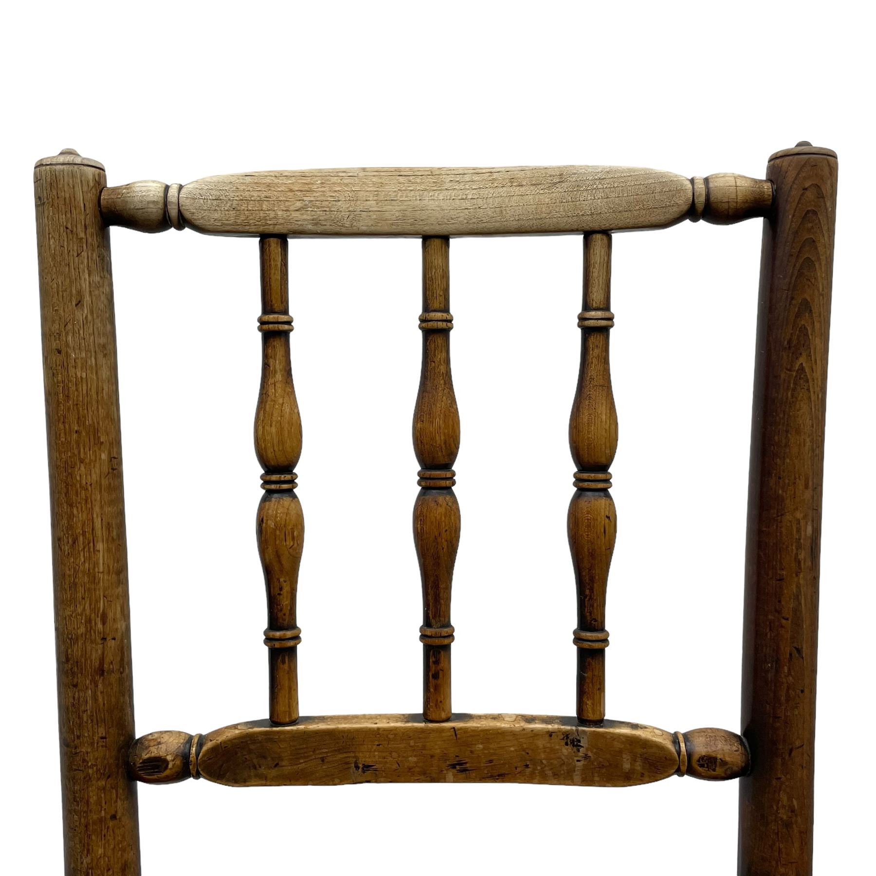 Set of four 19th century elm spindle back chairs, bar cresting rail over three turned vertical spindles, rush seat on turned supports united by turned stretchers 