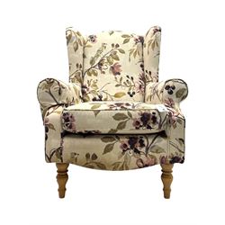 Hardwood-framed wingback armchair, upholstered in cream floral pattern fabric, on turned front feet