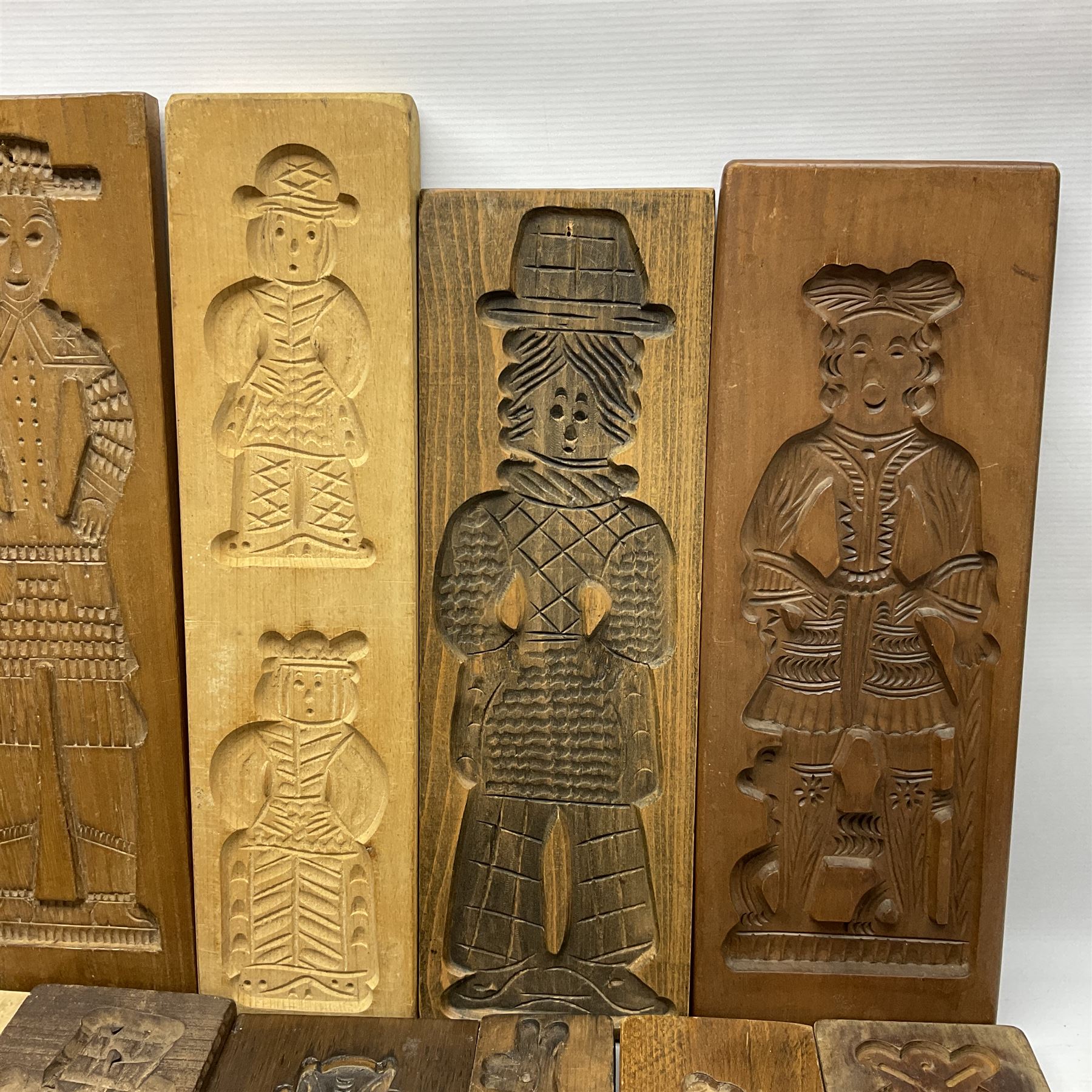 Collection of 20th century beech and other hardwood Dutch folk art Speculaasplank or biscuit moulds, most examples typically carved with figures in traditional dress, tallest H52cm