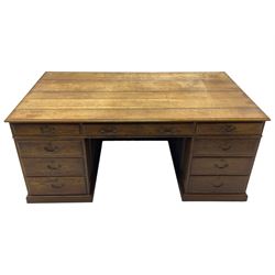 Large 20th century oak twin pedestal desk, moulded rectangular top over nine drawers, panelled pedestals, on moulded plinth base 