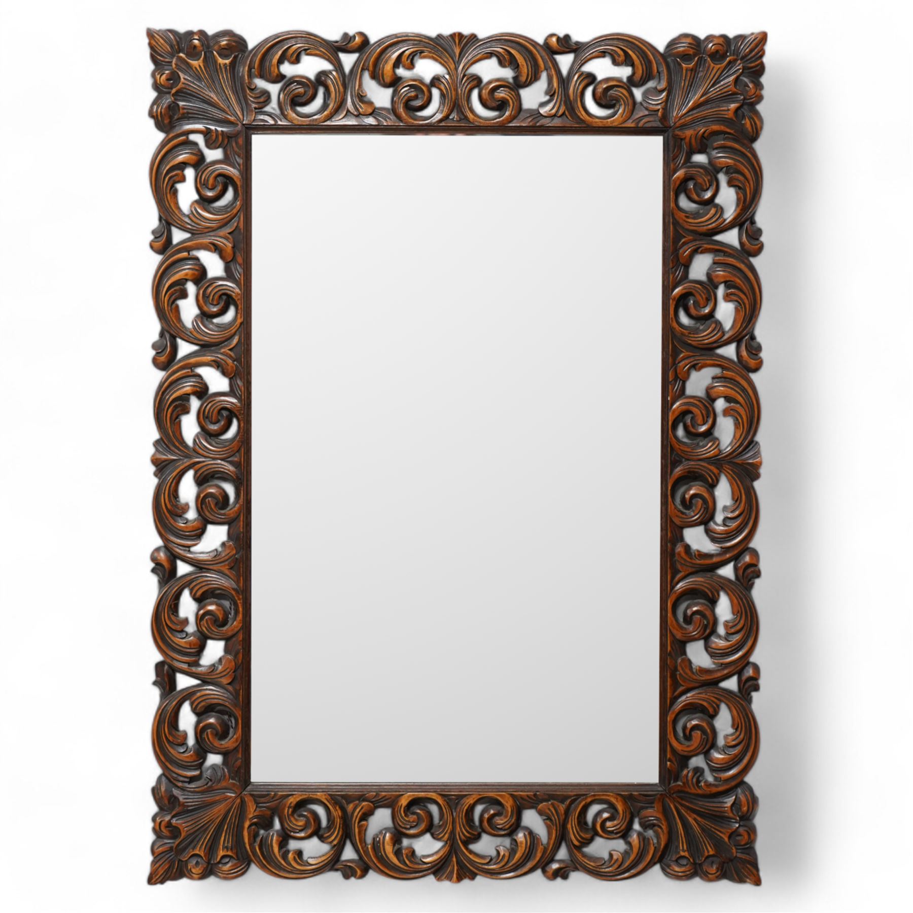 Early 20th century walnut framed wall mirror, bevelled mirror plate enclosed by carved frame, decorated with curling foliage 