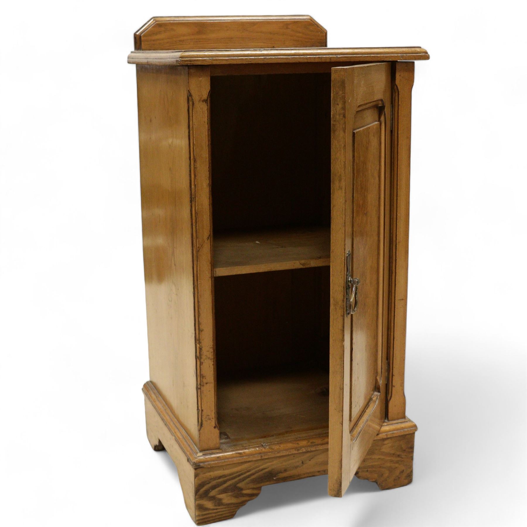 Late Victorian ash and walnut bedside pot cupboard, raised canted back over square moulded top, enclosed by single panelled door with figured walnut veneer, on bracket feet 