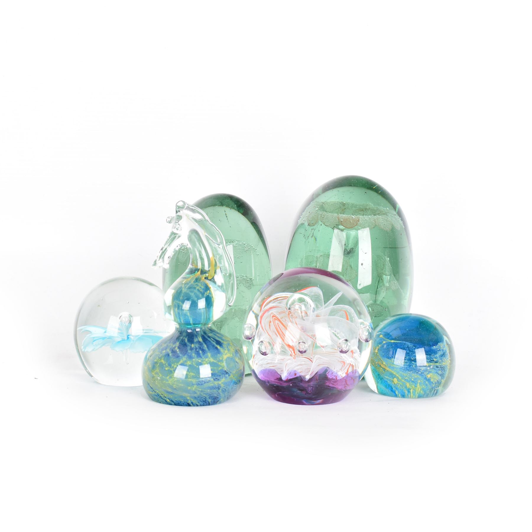 Two glass dump paperweights, with flower inclusions, together with four further glass paperweights