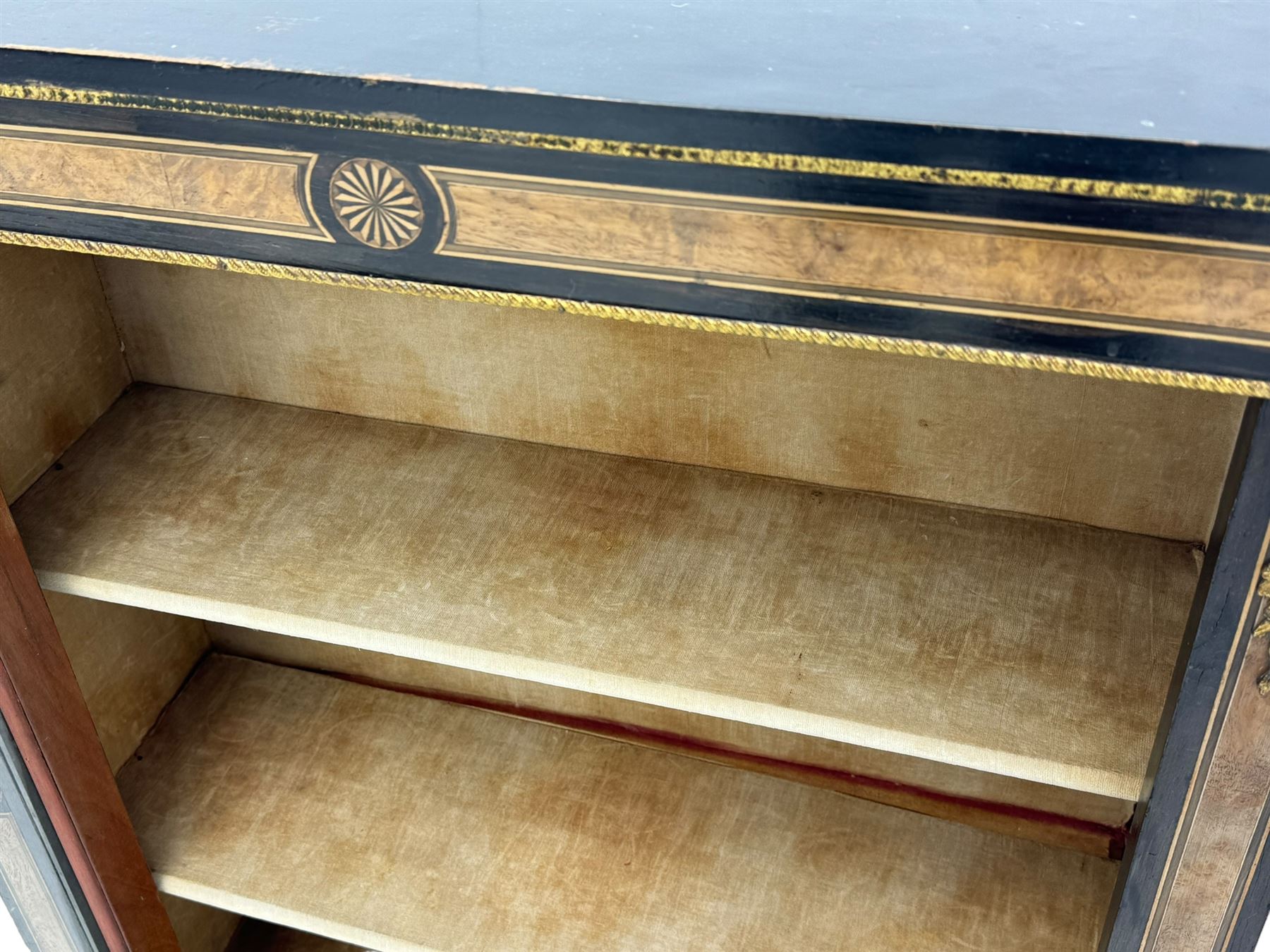 Victorian ebonised and walnut pier cabinet, rectangular top over figured frieze with central star motifs, enclosed by single glazed door, decorated with cast gilt metal mounts and beading, on chamfered plinth base 