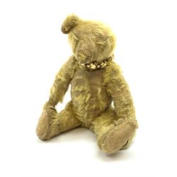 Early 20th century English teddy bear, with wood wool filled body with jointed limbs, felt covered paw pads, five claw stitching to feet and elongated arms with spoon shaped paws H14