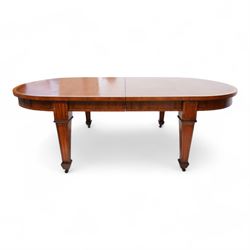 Late 19th to early 20th century mahogany and satinwood banded dining table, telescopic extending action, with three additional leaves, figured frieze rails over square tapering supports with spade feet, inlaid with satinwood panels, on brass castors 