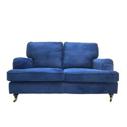 Howard design - two-seat sofa upholstered in blue fabric, traditional shape with rolled arms, on walnut finish turned feet with brushed metal cups and castors