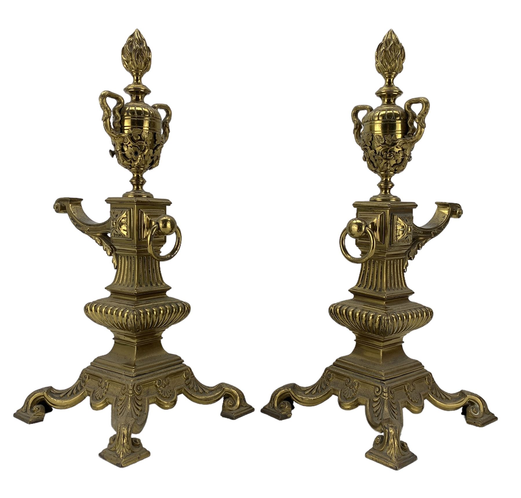 Pair of late Victorian cast and gilt brass fire dogs, circa 1894, with flaming urn finials raised upon columnar supports and four scroll feet, Rd227713, H47cm  