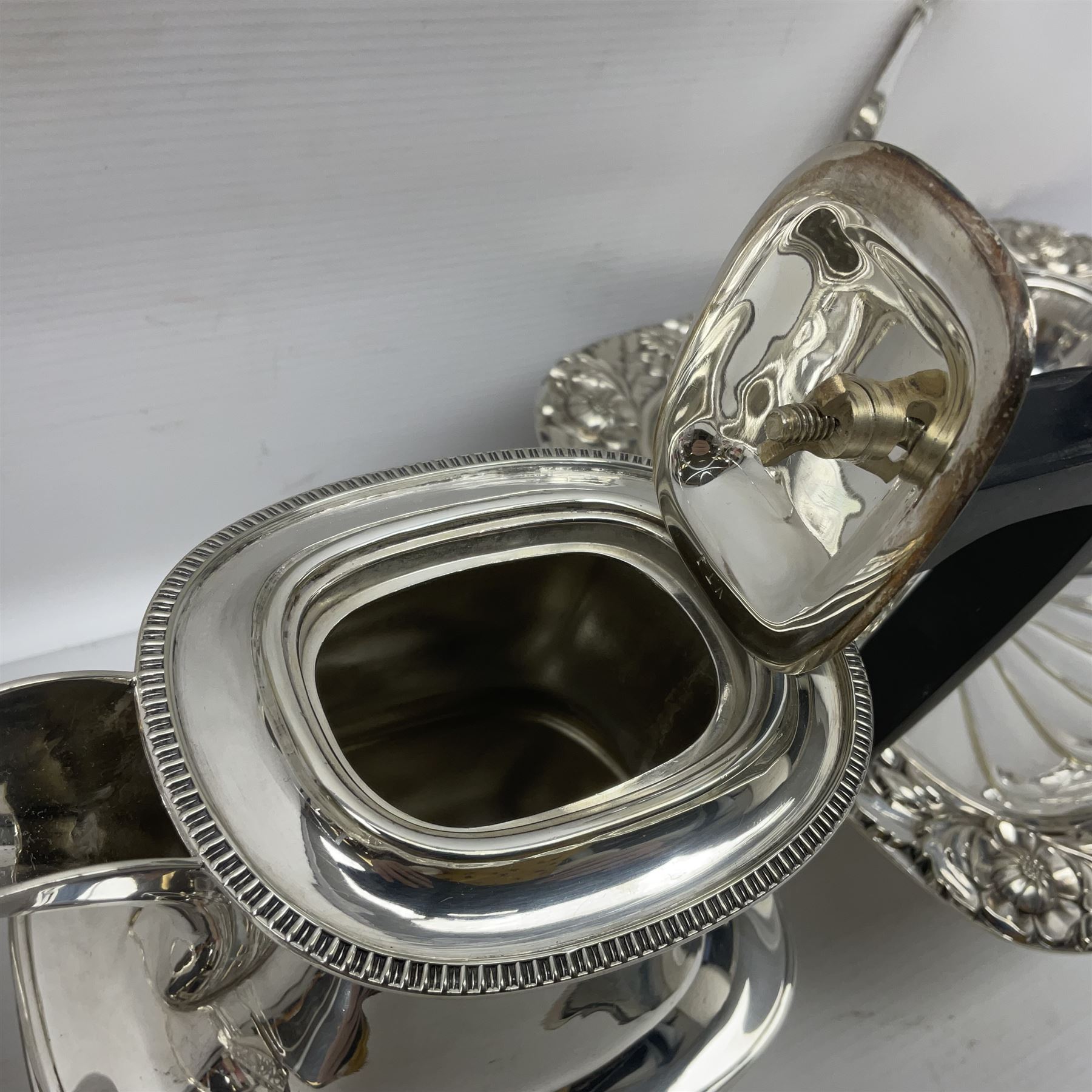 Edwardian silver plated swing handled basket, with pierced sides, engraved May 18 1904, with engraved initial A to handle, upon four ball and claw feet, together with other silver plated item including a similar swing handled basket, with embossed floral border, upon a rectangular pedestal, an egg coddler, with lion mask handles, hot water pot and a moulded glass biscuit barrel, coddler H22cm