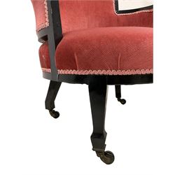 Early 20th century ebonised hardwood-framed armchair, rolled back and curved arms, upholstered in pink fabric, on square tapering front supports with spade feet, brass and ceramic castors 