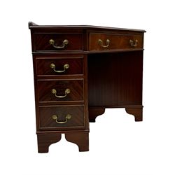 Late 20th century mahogany corner desk, leather inlaid top with gilt tooling, central frieze drawer flanked by two banks of four graduated drawers, raised on shaped bracket supports 