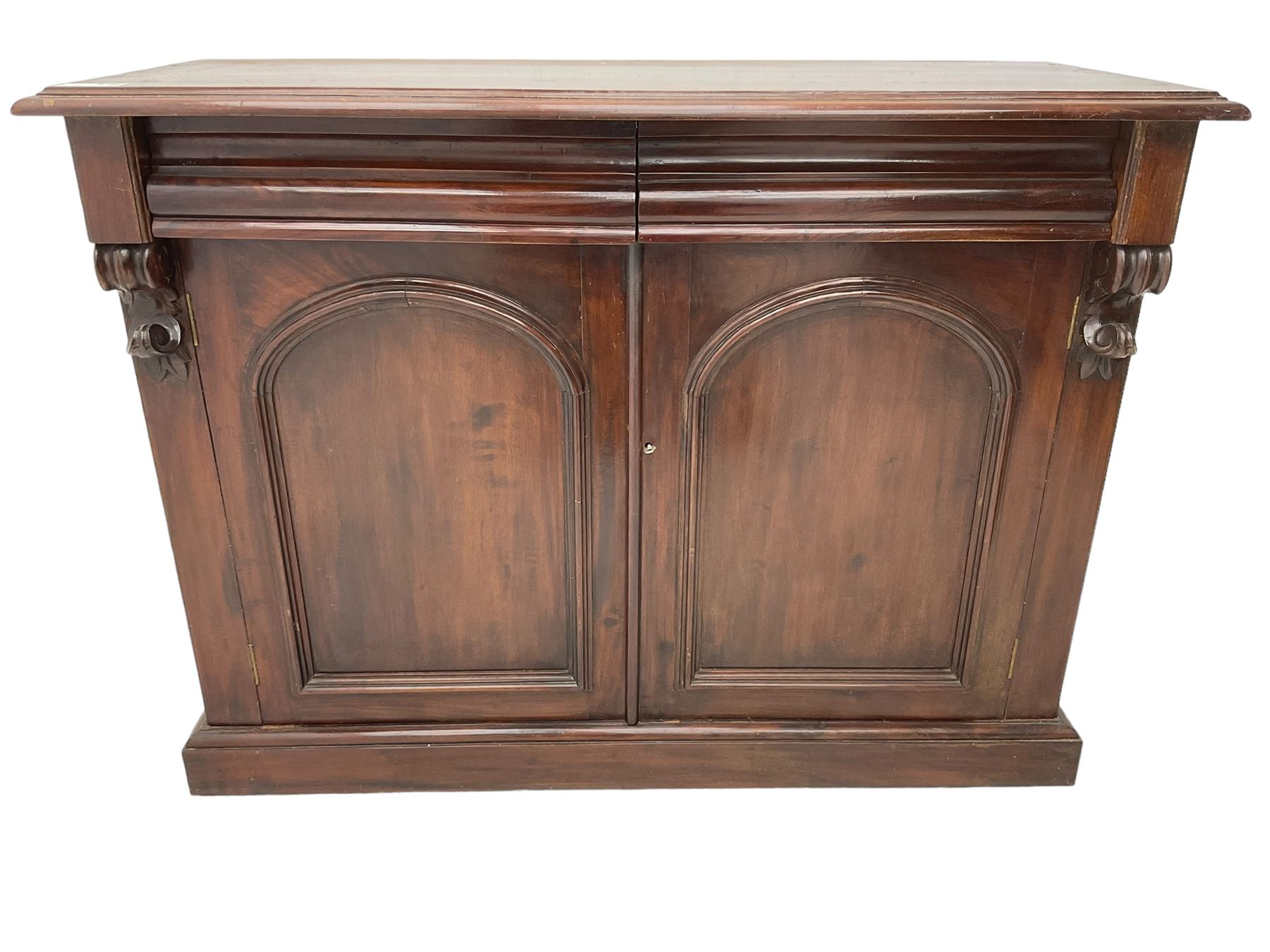 Victorian mahogany chiffonier, raised shaped back with foliage scroll carved mounts, on fretwork and carved bracket supports, moulded rectangular top over two frieze drawers and double panelled cupboard, on moulded plinth base