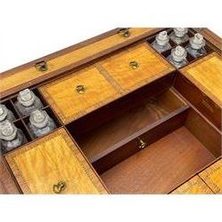 Late 19th century mahogany and satinwood dressing chest, the raised middle section hinges to reveal an interior fitted with lidded compartments, removable tray, single drawer and glass scent bottles, lift-up bevelled mirror with adjustable hinged mechanism, fitted with a further eight cock-beaded graduating drawers and curved kneehole with double cupboard, square tapering supports on brass cups and castors, inlaid throughout with checkered stringing, ornate Rococo cast gilt metal handles