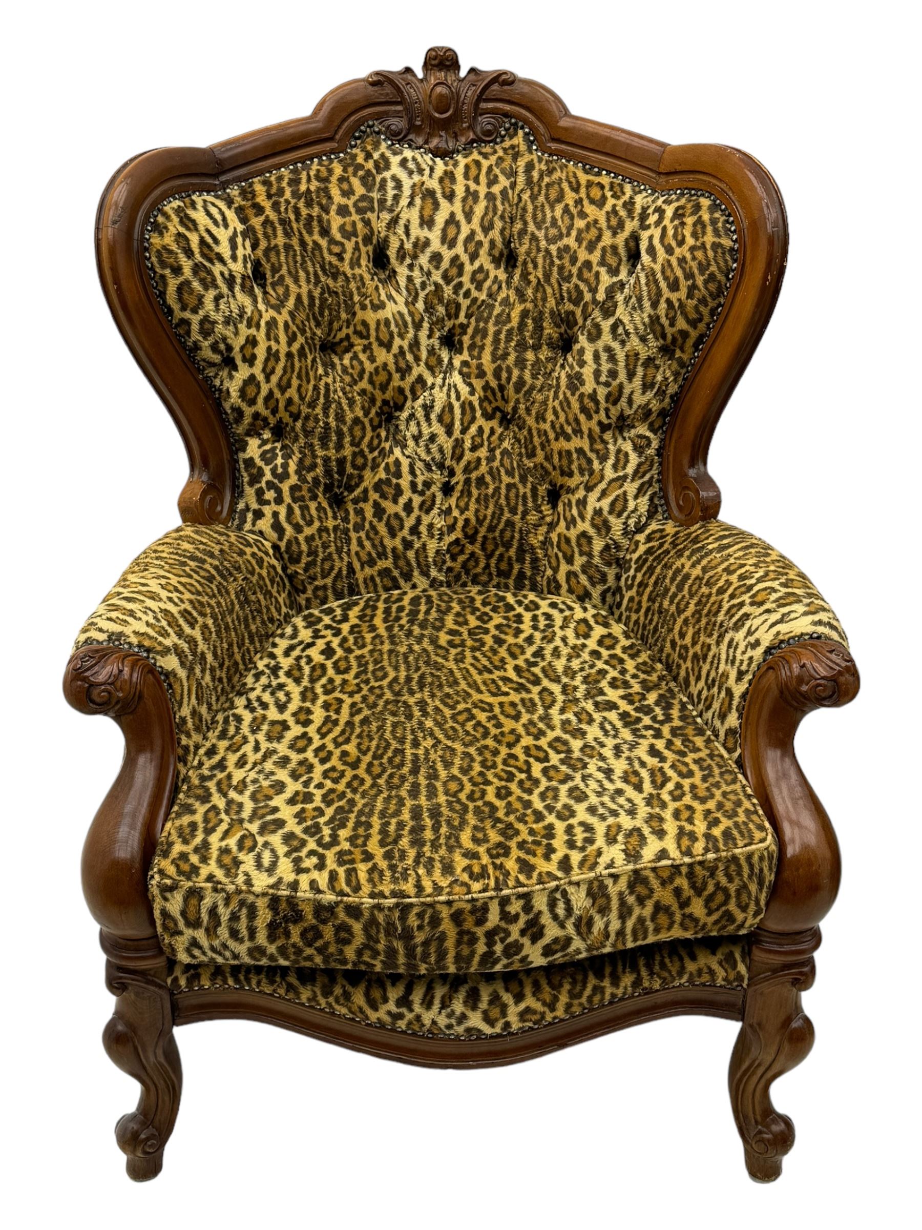 Pair of Victorian design stained beech armchairs, upholstered in leopard print fabric, with carved top rail over button-tufted backrest, scroll arms, serpentine front rail, raised on cariole supports