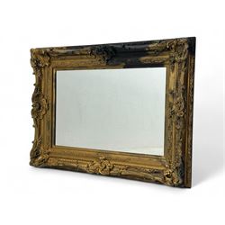 Victorian design giltwood wall mirror, richly carved with scrolls, shells, and foliate mot...