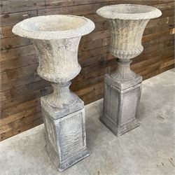 Pair of large Georgian design cast stone garden urns, egg and dart border, tapering column on square base, raised on square column