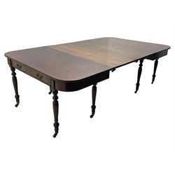 George III mahogany extending dining table, reed moulded rectangular top with rounded corners, two D-ends each fitted with two drawers, two additional leaves, on turned supports with ribbed brass cups and castors 