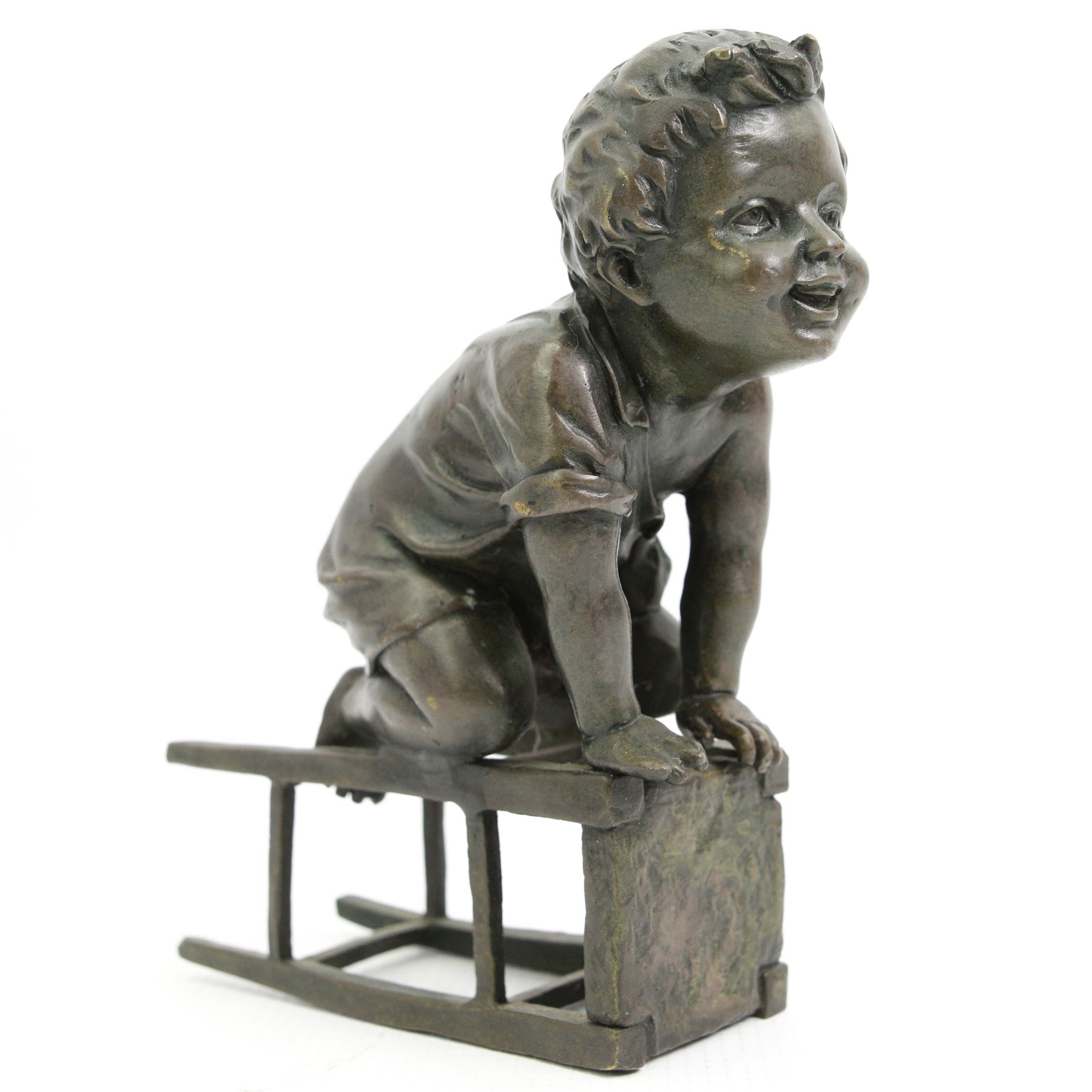 After Juan Clara (Spanish 1875-1957) - Bronze of a child playing on an upturned stool H15cm, signed underneath stool 