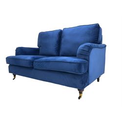 Howard design - two-seat sofa upholstered in blue fabric, traditional shape with rolled arms, on walnut finish turned feet with brushed metal cups and castors