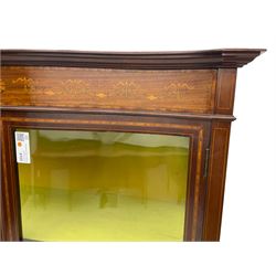 Edwardian inlaid mahogany serpentine display cabinet, projecting moulded cornice over figured frieze inlaid with tailing bellflowers and central fan motif, enclosed by two glazed doors, on square tapering supports with splayed terminals 