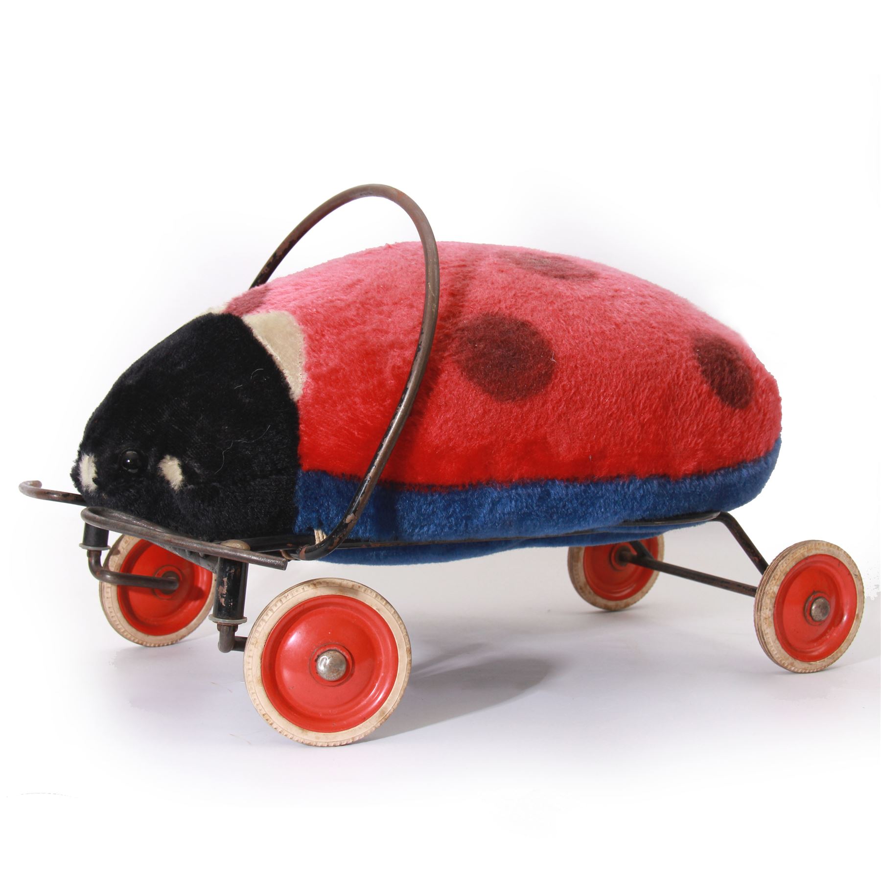 Steiff child's ride on ladybird, circa 1950s, the mohair body with red and black spotted seat, black and white face and blue underbelly, upon a metal frame with rubber and metal wheels, H30cm, W52cm