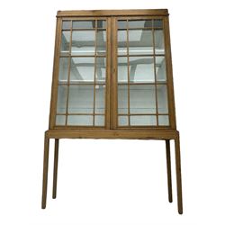 Georgian stripped pine bookcase display cabinet, plain moulded cornice over two glass-panel doors with multiple panes, enclosing white painted interior with three shelves, raised on square supports