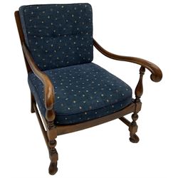 Early 20th century stained beech framed armchair, cane panel back over scrolled arm terminals, raised on turned supports united by turned H-stretcher, with patterned blue upholstered loose back and seat cushions