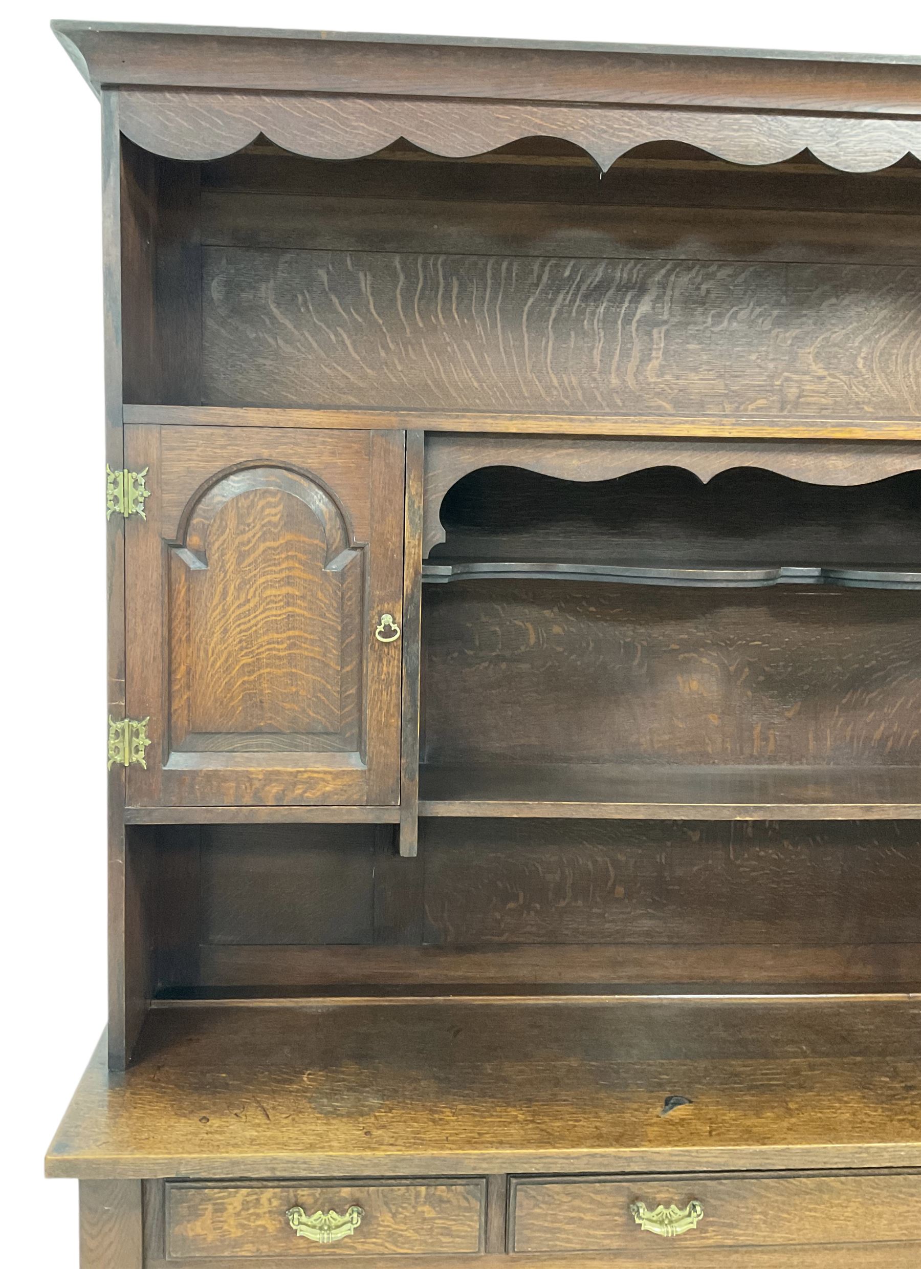 Early 20th century Georgian design oak dresser, projecting cornice with shaped apron over a three-tier plate rack with flanking fielded spice cupboards, the base fitted with three drawers, on turned supports