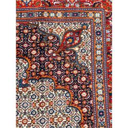 Persian Bidjar ivory and indigo ground rug, large central rosette medallion surrounded by floral herati motifs, crimson ground border decorated with repeating palmettes, within guard stripes decorated with small flower head motifs 