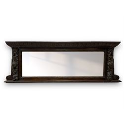 Victorian heavily carved oak wall mirror, projecting gadroon carved ovolo cornice, bevelled mirror plate within a lunette carved frame, decorated with applied fruit and foliage carved mounts, scroll carved brackets 