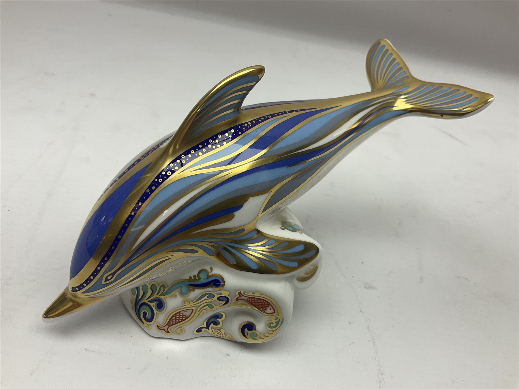 Three Royal Crown Derby paperweights, comprising Bottlenose Dolphin, Baby Bottlenose Dolphin and Striped Dolphin, all with gold stoppers 