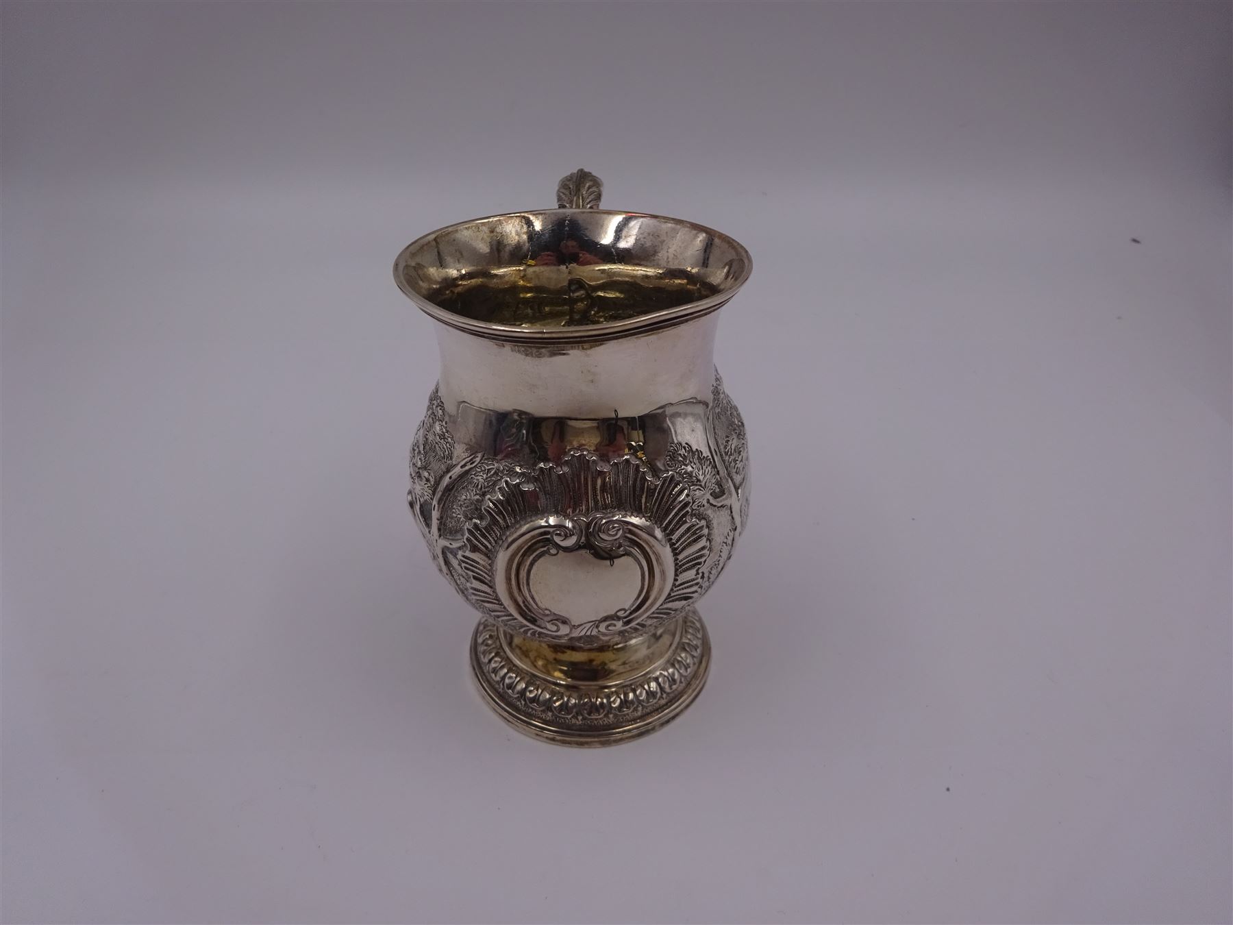 William IV silver christening mug, of waisted form, the body embossed with game birds in a countryside setting and a blank circular cartouche, with acanthus leaf capped scroll handle, upon a circular stepped foot, hallmarked Edward, Edward junior, John & William Barnard, London 1831, H10.2cm