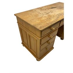 Waxed pine twin pedestal desk, rectangular top over nine drawers, on compressed bun feet 