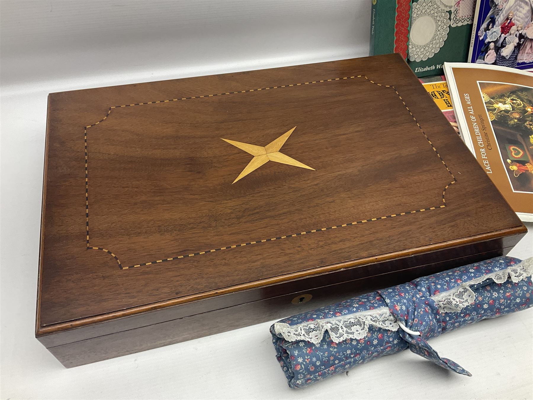 Collection of lace making wooden bobbins, together with lace making books and a handmade storage box