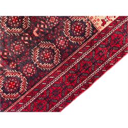 Persian Baluchi dark indigo and crimson ground rug, the field decorated with rows of repeating Pitrak motifs and surrounded by small bird and flower head motifs, floral urn decorated spandrels, repeating Pitrak border within guard stripes