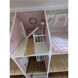 Large three storey modern dolls house, painted white with latticed windows, grey roof and metal fencing, with decorated interior, together with two dolls house garden rooms and two conservatories