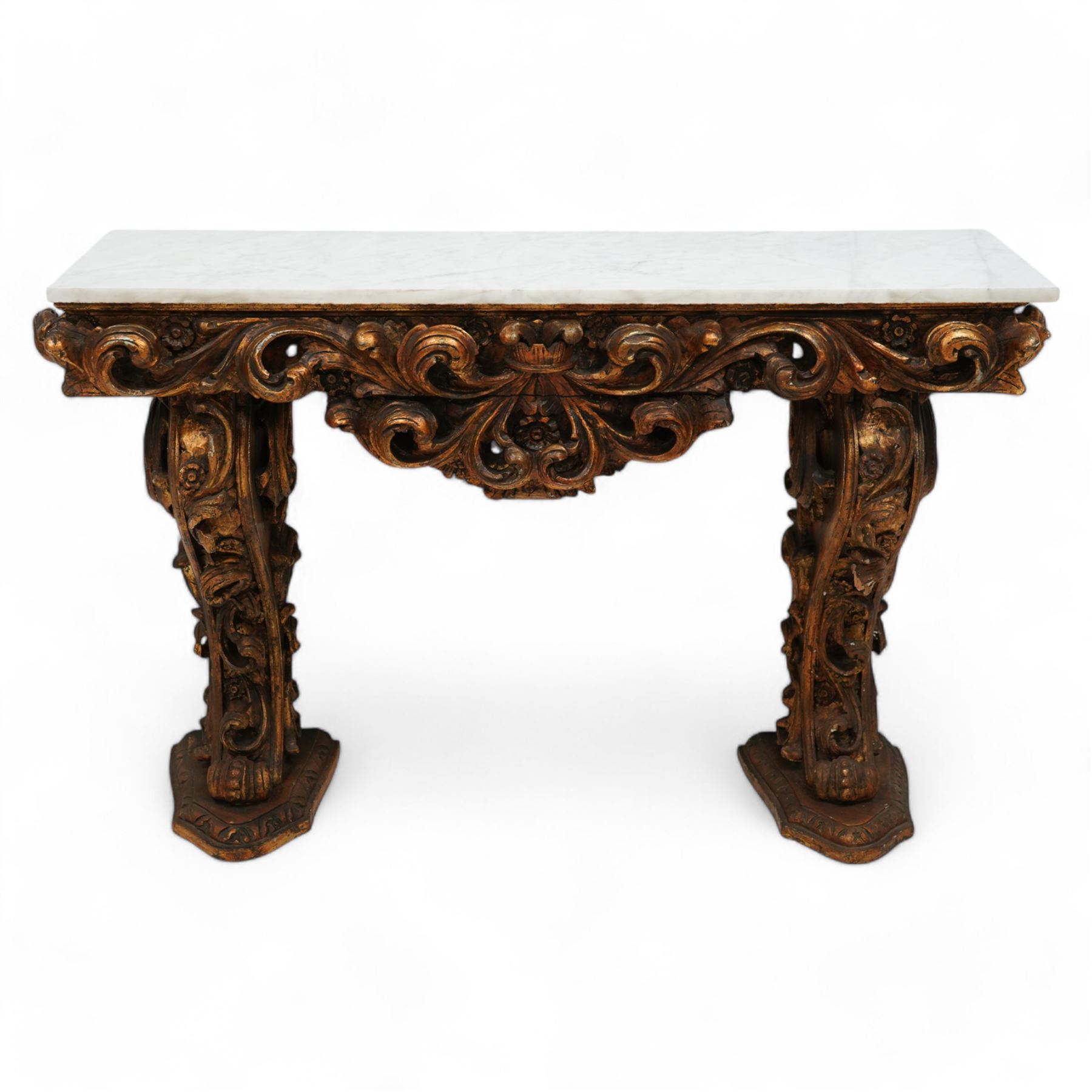 Early 20th century Baroque design ornate giltwood console table with rectangular marble top, the heavily moulded protruding and pierced frieze decorated with a central crowned foliage cluster with extending scrolling acanthus leaves, the shaped end supports decorated with further moulded gilt foliate scrolls interspersed with flower heads, on shaped stepped bases carved with floral patterns 