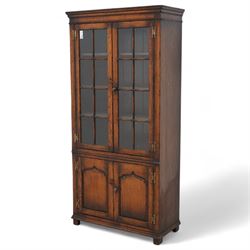 Late 20th century oak enclosed bookcase, moulded cornice over two astragal glazed doors en...