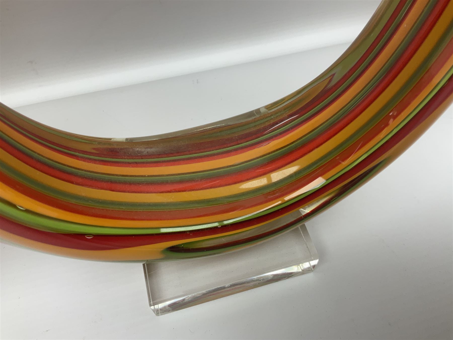 Three art glass sculpture, coiled form with multicolour stranded, upon clear glass plinth, unsigned, largest H27cm