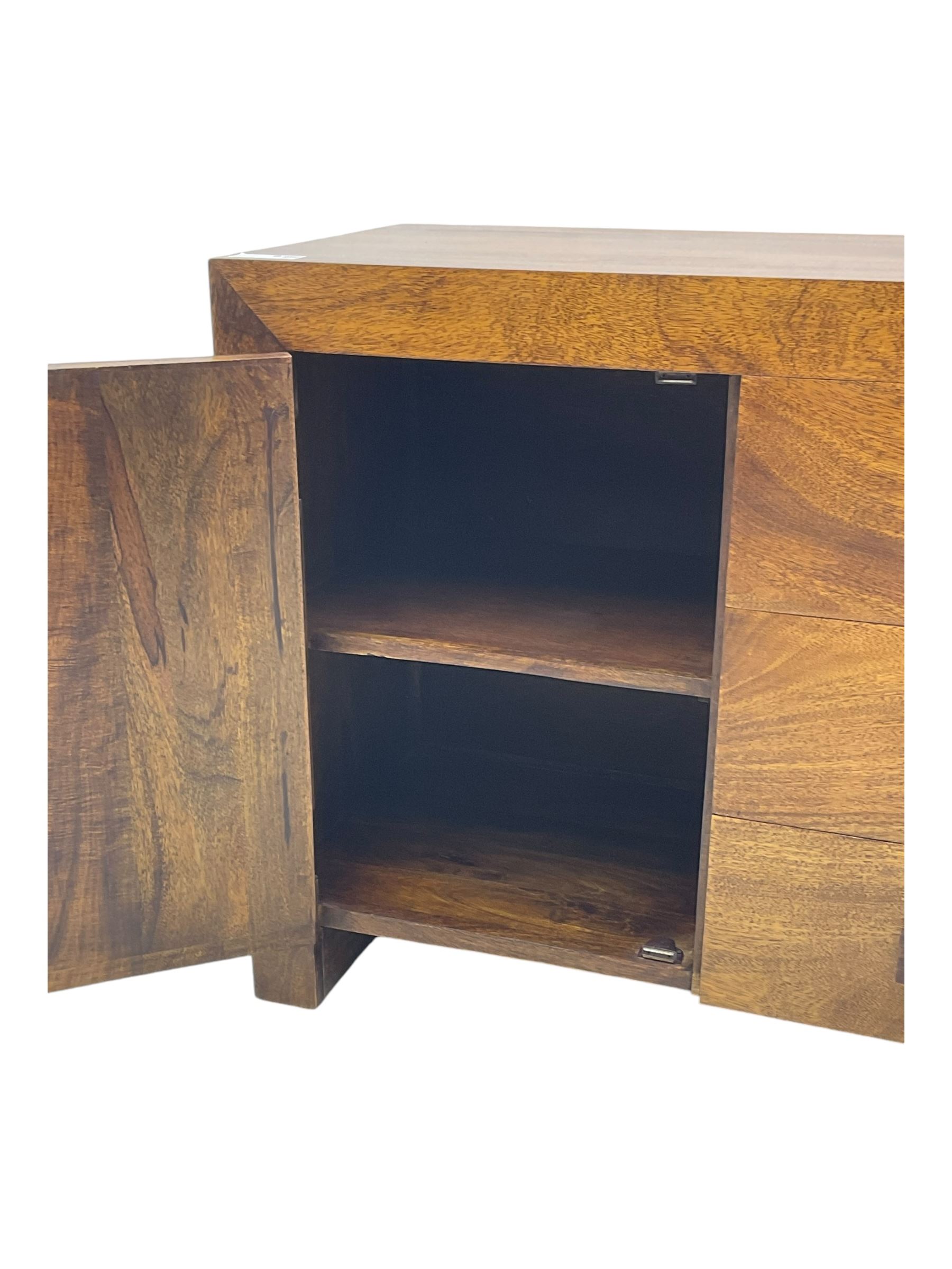 Contemporary Dakota mango wood sideboard, plain rectangular top over three central drawers flanked by cupboards with shelving, each with square pulls, raised on stile supports