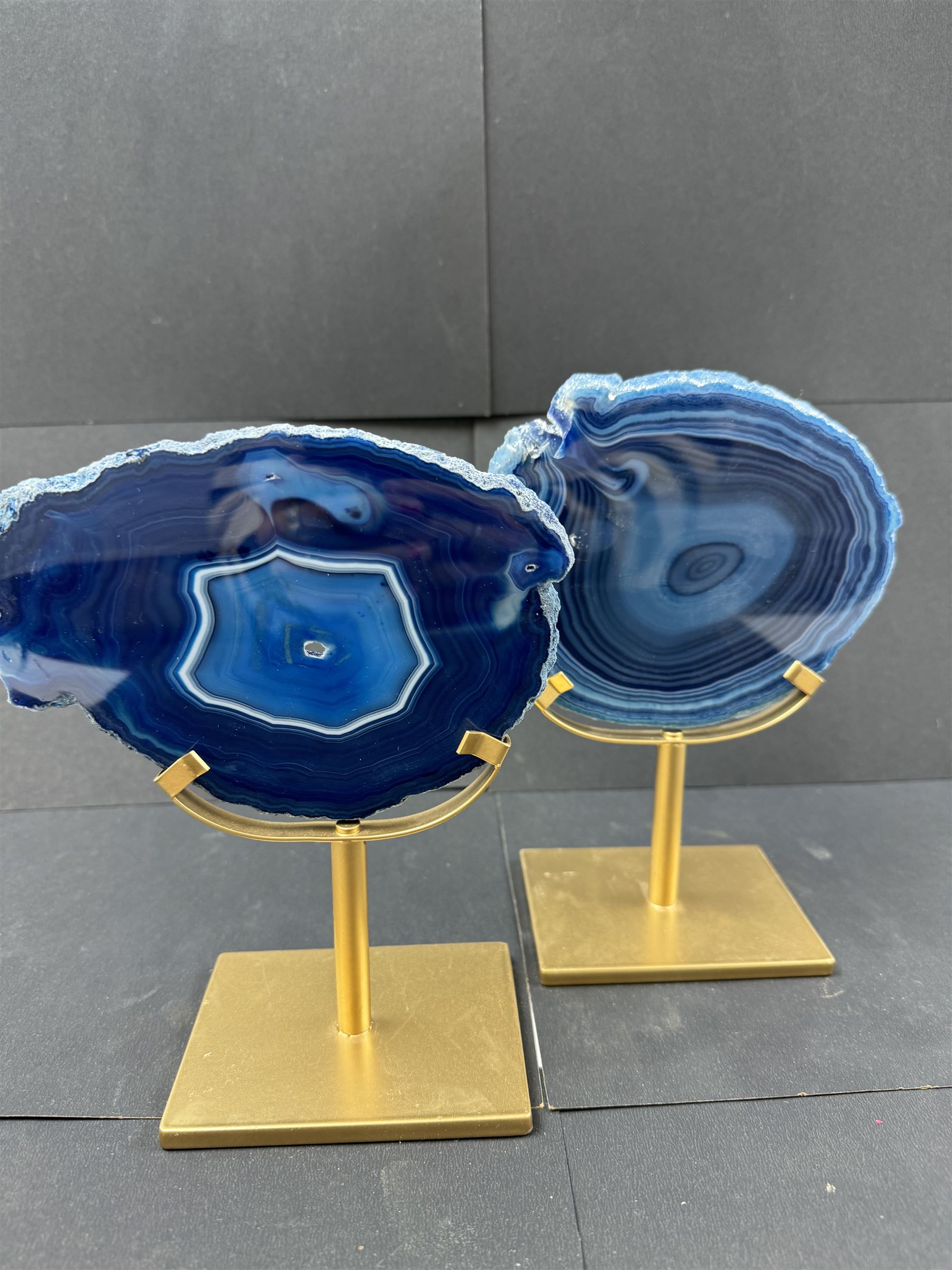 Pair of blue agate slices, polished with rough edges, raised upon gilt metal stands, H20cm