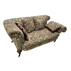 Mid-19th century walnut framed two-seat sofa, rolled arms over sprung seat, single drop-end action, raised on turned and fluted feet with brass cups and castors, upholstered by E & S Gott in traditional floral pattern fabric decorated with urns