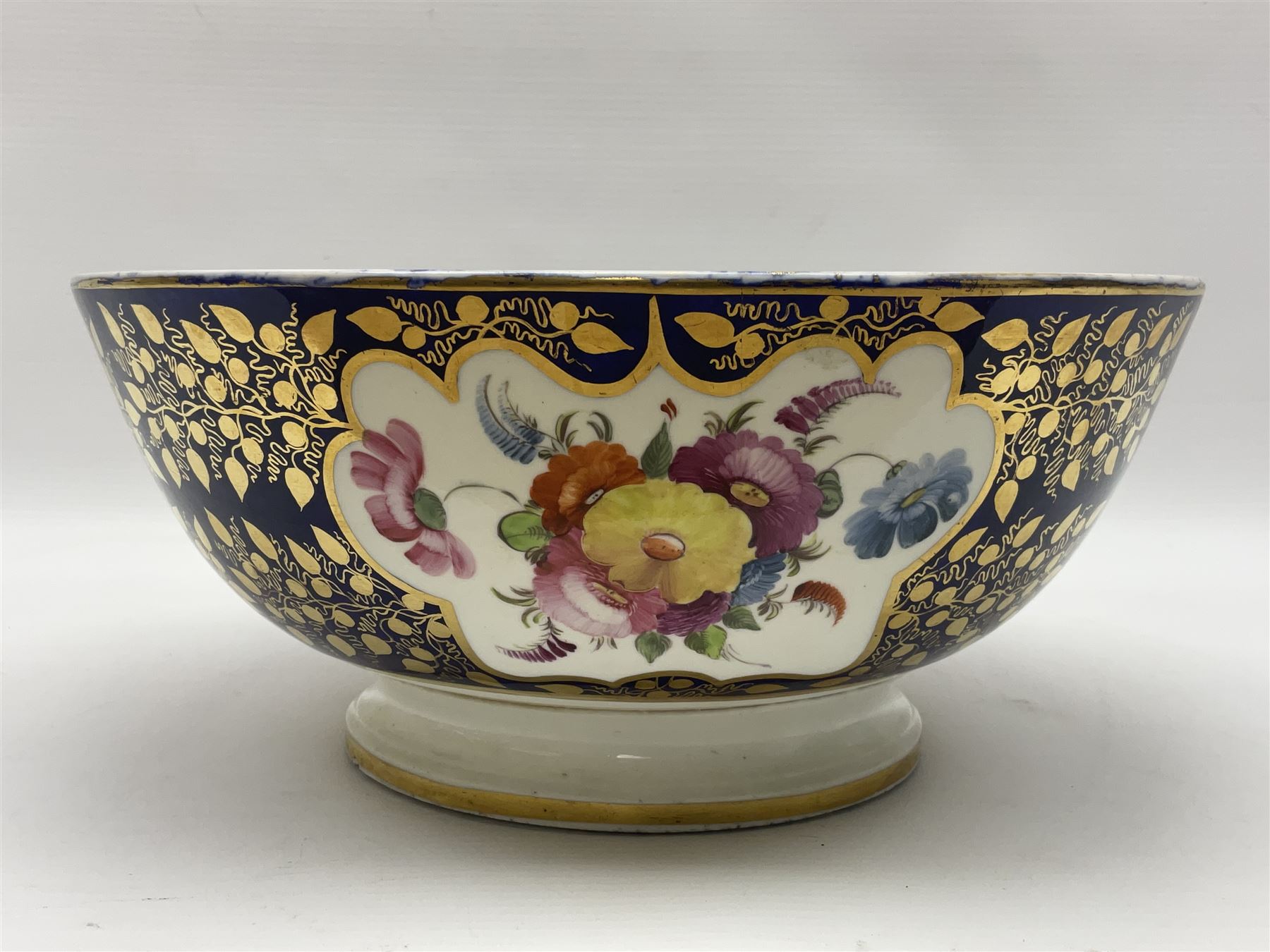 19th century continental bowl, decorated with hand painted floral sprays amongst gilt foliate decoration on a cobalt blue ground, D27.5cm