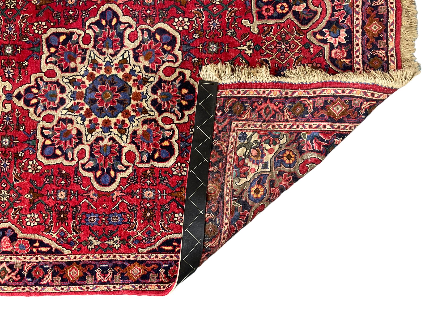 Persian Hamadan crimson ground rug, central floral pole medallion with matching spandrels, the guarded indigo border with interlaced palmettes