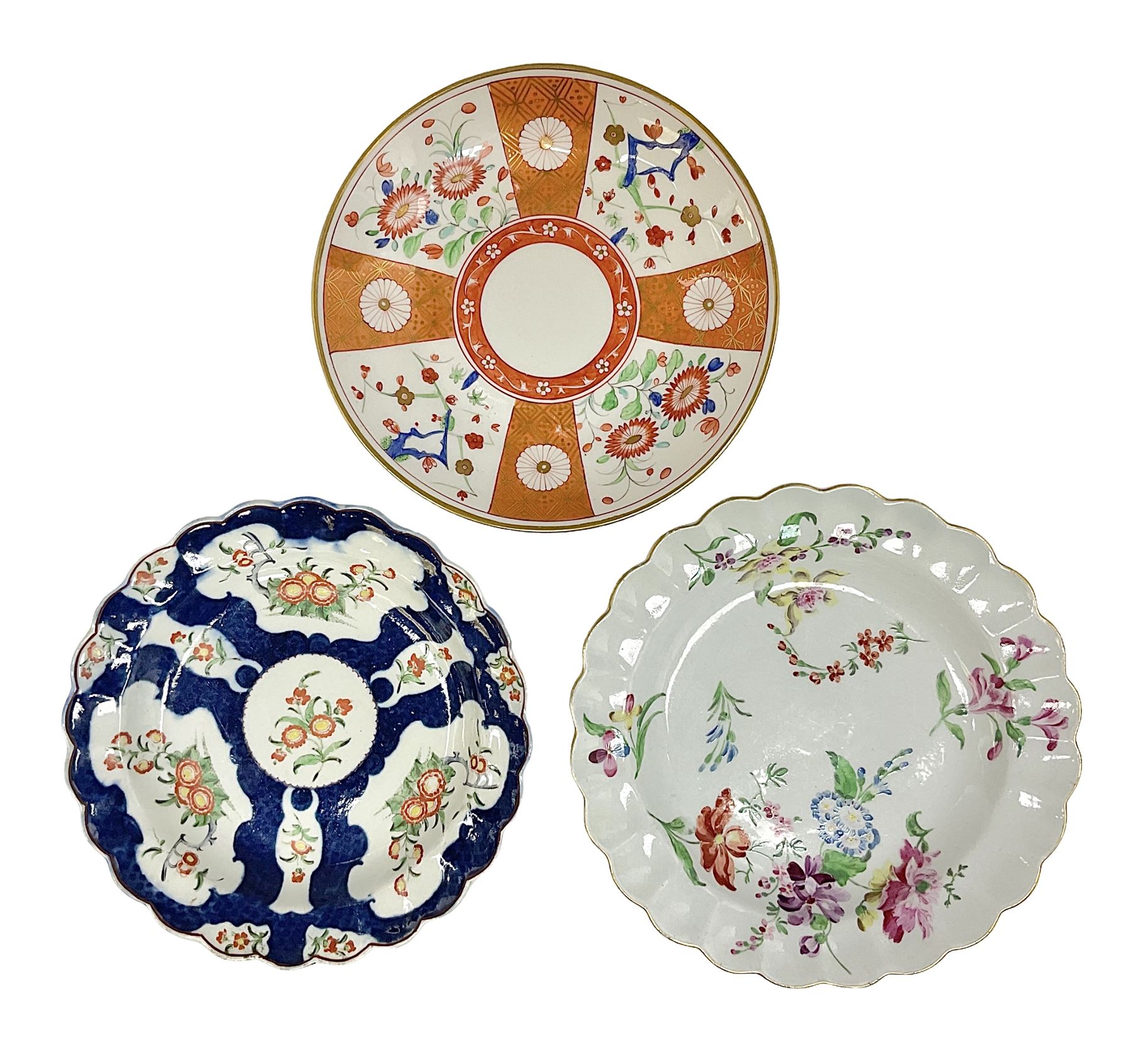 Three 18th century Worcester desert dishes, the first example decorated in the Scarlet Japan pattern, circa 1790, painted with alternating panels of Kakiemon style prunus blossom and chrysanthemum, and orange ground panels with gilt fret detail, D19cm, the second example, circa 1770, decorated with Kakiemon style chrysanthemums and foliage within shaped reserves upon a blue scale ground, with fretted square pseudo mark beneath, D19cm, and the third, circa 1770, painted with polychrome floral sprays and sprigs, D20cm