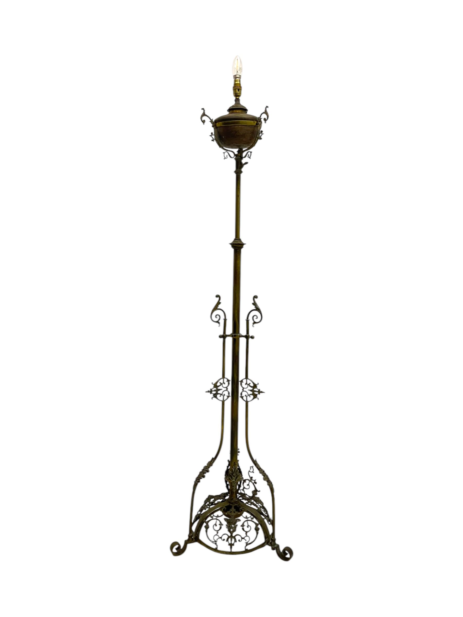 Victorian brass converted oil lamp stand, telescopic stem with scrolled uprights terminating to scrolled feet, dished base decorated with scrolling cast metal work and grotesque masks 