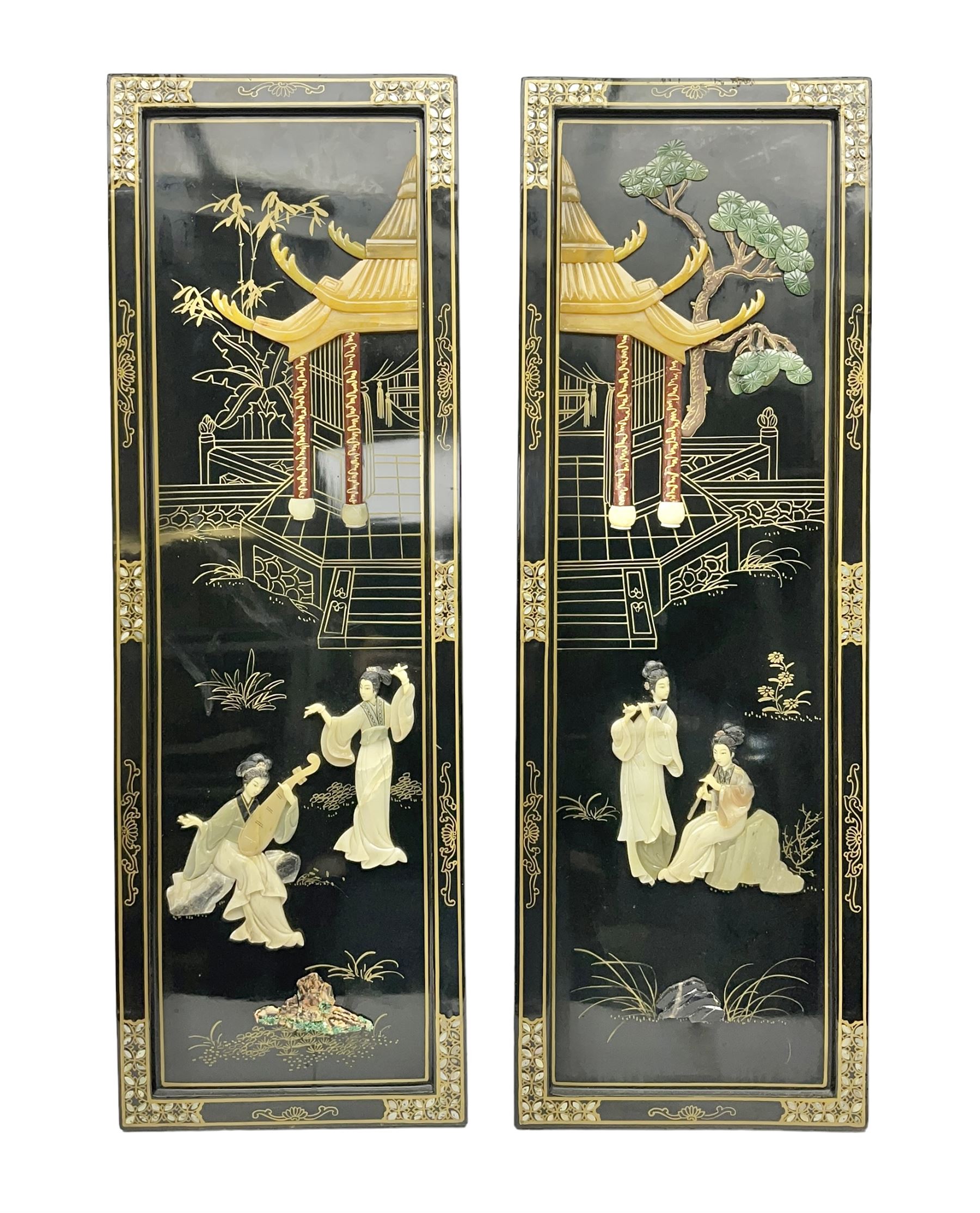 Two 20th century Chinese lacquered wall plaques, decorated in relief with female figures playing instruments beneath a pagoda, within gilt and mother of pearl inlaid borders, H92cm