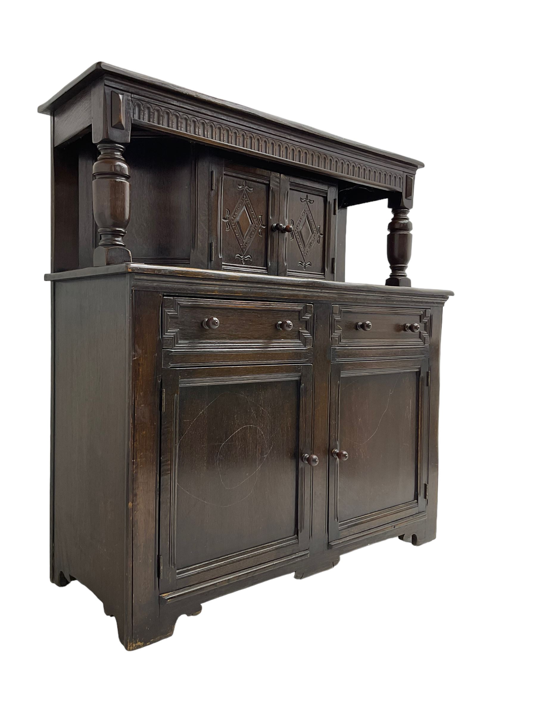 20th century oak court cupboard, arcade carved frieze over baluster supports with demi-hexagon cupboard with lozenge carved facias, the base fitted with two drawers over double cupboard, each with heavily moulded edges